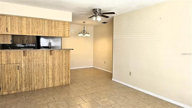 a view of kitchen with stainless steel appliances granite countertop white cabinets and a refrigerator
