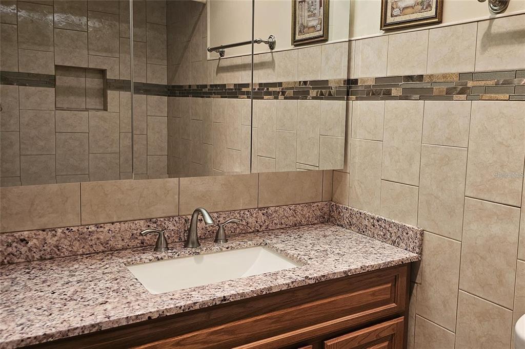 4330 Tahitian Gardens Circle, Unit C Holiday, FL 34691 - Photo 10 of 20 a bathroom with a granite countertop sink and a mirror