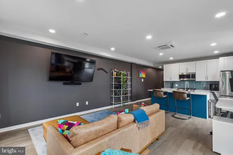 a kitchen with a refrigerator a stove microwave oven with a dining table and chairs