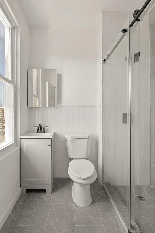 9 Kane Place Brooklyn, NY 11233 - Photo 6 of 18 a bathroom with a toilet a sink and a shower