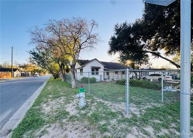 a view of a house with backyard and trees