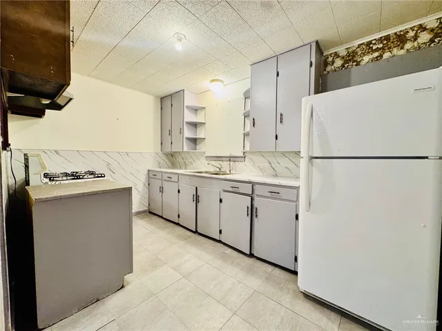a kitchen with white cabinets and white appliances