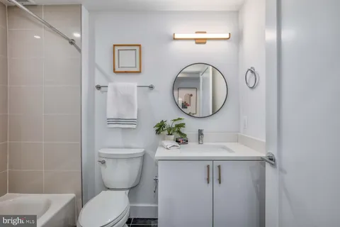a bathroom with a toilet sink vanity and mirror