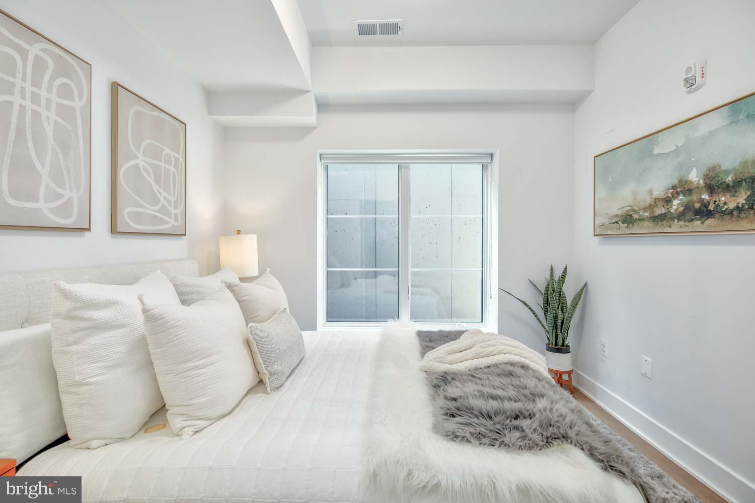 2310 4th Street Northeast, Unit FIVE Washington, DC 20002 - Photo 10 of 19 a bedroom with a bed and a painting on the wall
