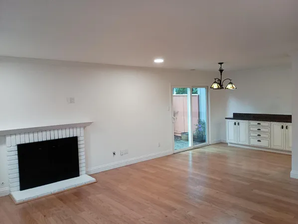 an empty room with windows and fireplace