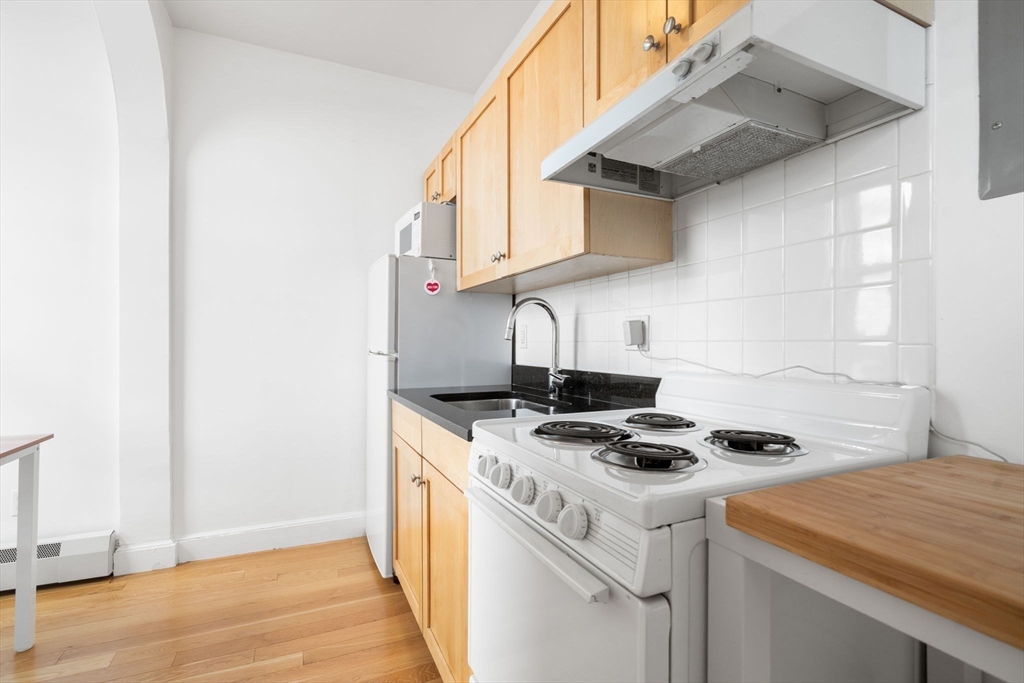 483 Beacon Street, Unit PH4 Boston, MA 02115 - Photo 13 of 18 a kitchen that has a stove and a microwave