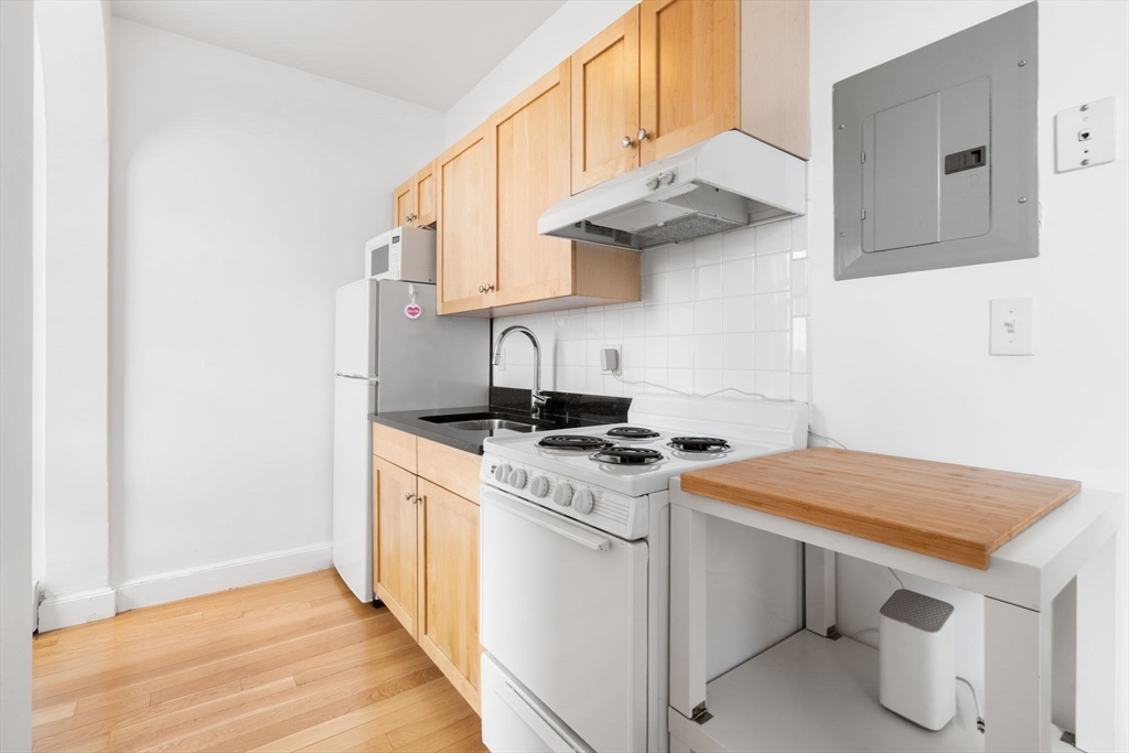 483 Beacon Street, Unit PH4 Boston, MA 02115 - Photo 6 of 18 a kitchen with stainless steel appliances white cabinets and a sink
