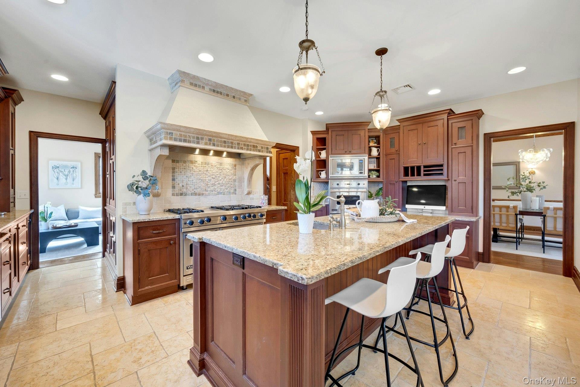 15 Carstensen Road Scarsdale, NY 10583 - Photo 6 of 35 a kitchen with stainless steel appliances kitchen island granite countertop a stove a sink a oven a dining table and chairs