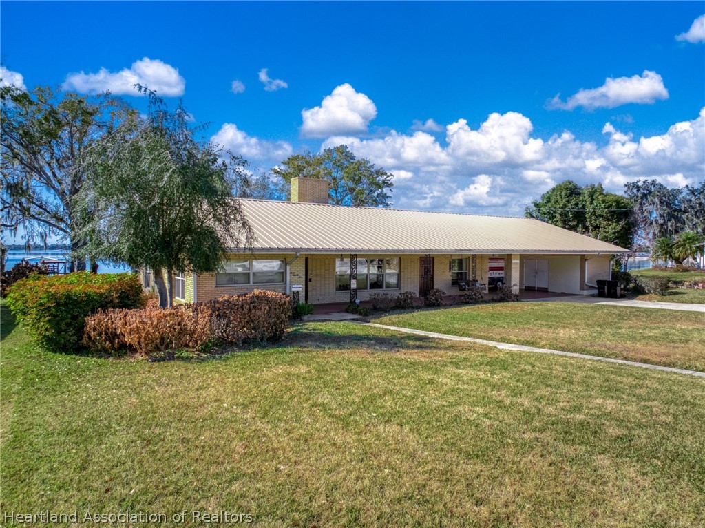 325 Sunset Road Frostproof, FL 33843 - Photo 1 of 48 a front view of a house with a garden