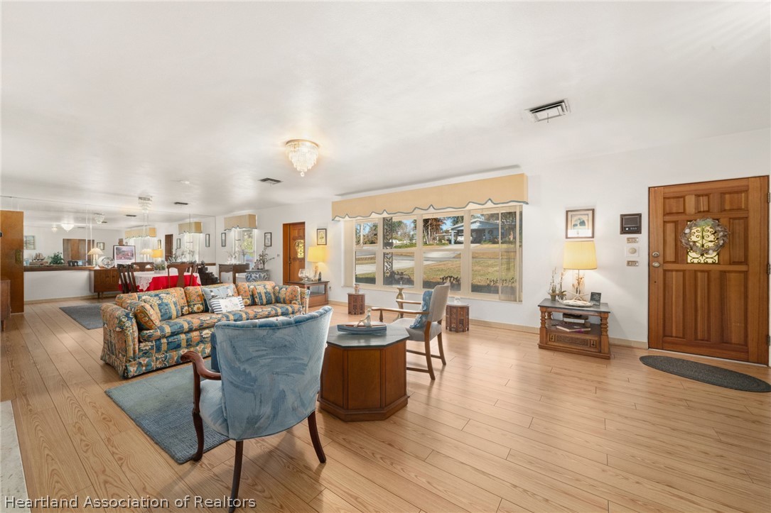 325 Sunset Road Frostproof, FL 33843 - Photo 14 of 48 a living room with lots of furniture and wooden floor