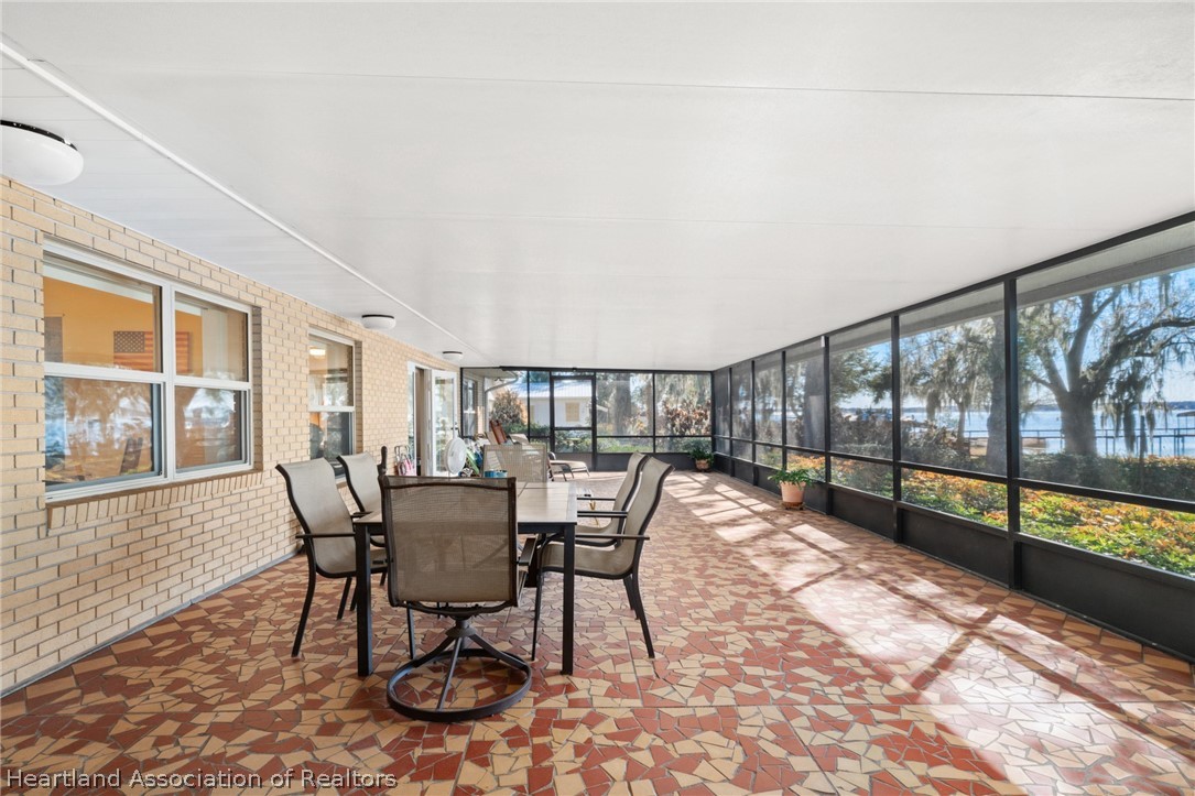 325 Sunset Road Frostproof, FL 33843 - Photo 42 of 48 a view of a dining room with furniture large windows and wooden floor