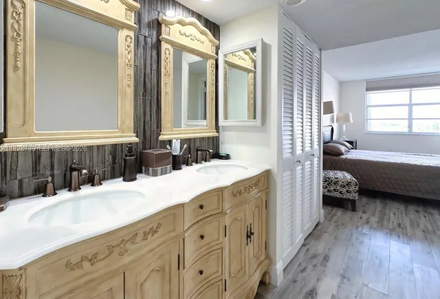 a bathroom with a double vanity sink a mirror and a bathtub