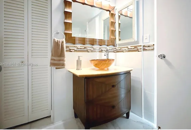 a utility room with a sink and a mirror