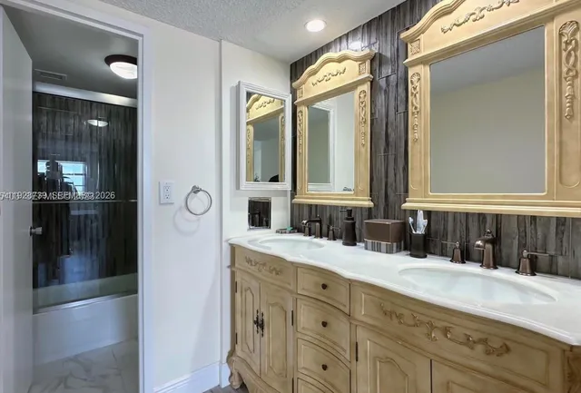a bathroom with a granite countertop sink vanity and mirror