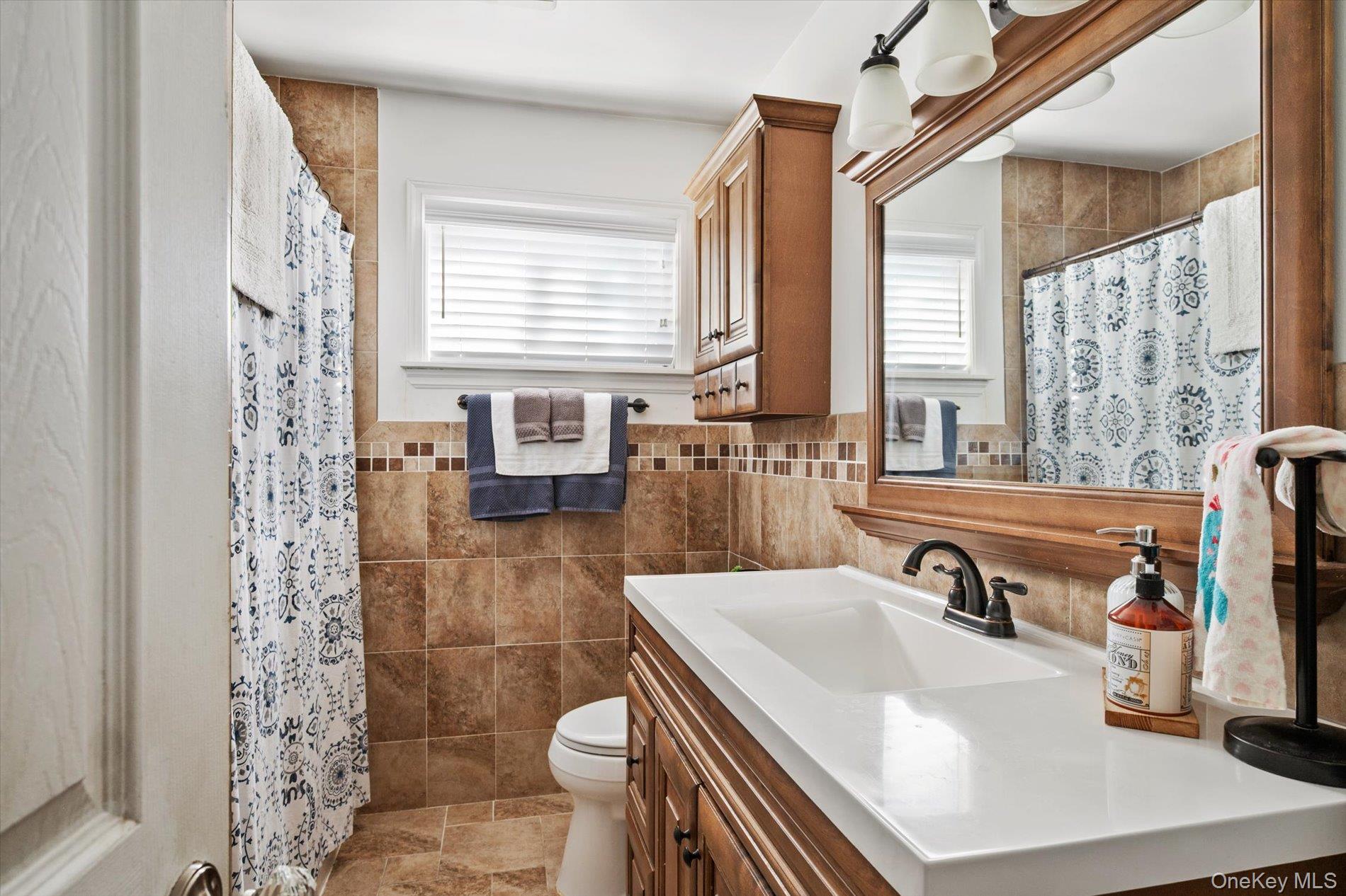 249 Hampton Road West Babylon, NY 11704 - Photo 12 of 22 a bathroom with a sink toilet a mirror and shower