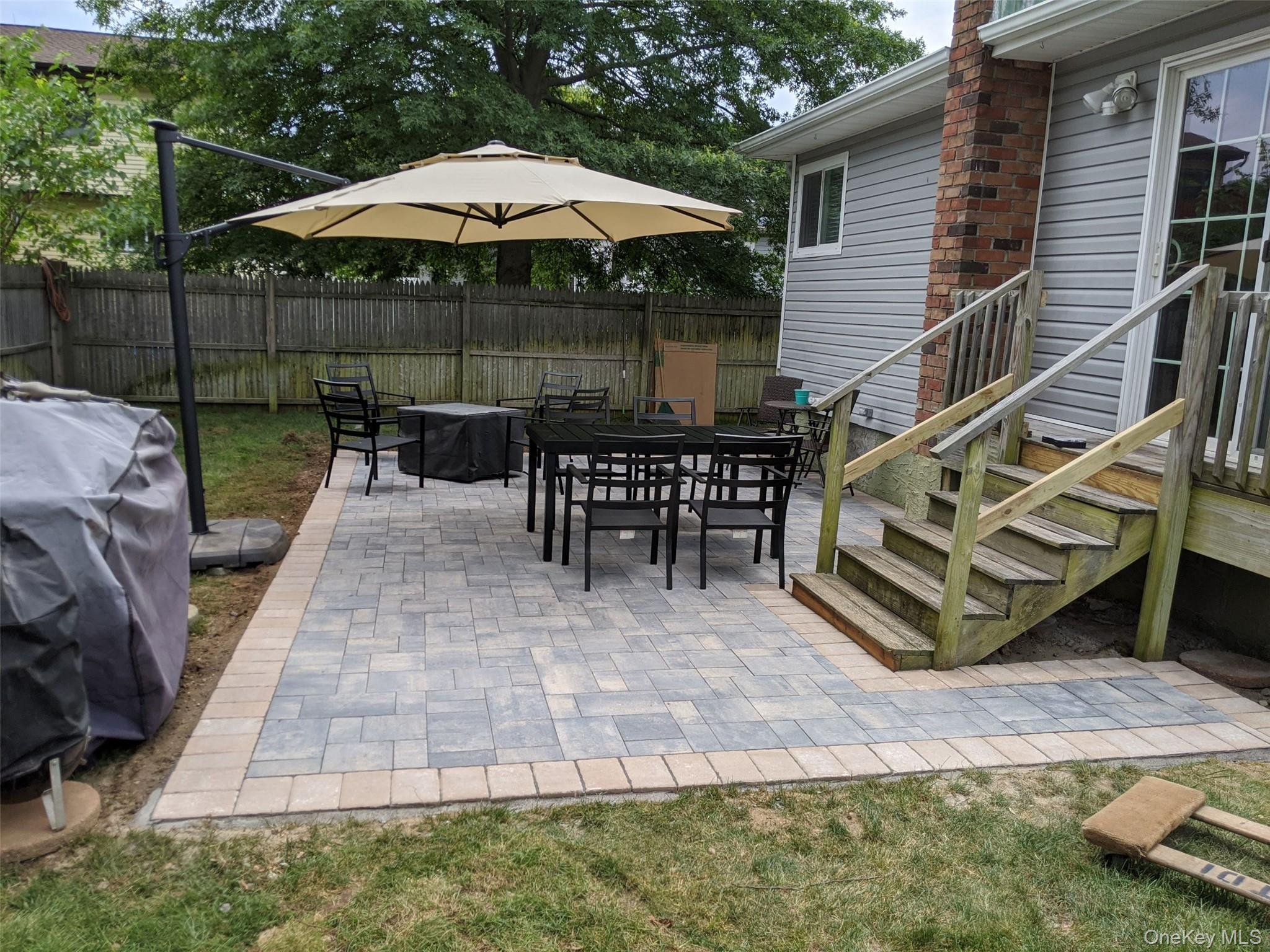 249 Hampton Road West Babylon, NY 11704 - Photo 21 of 22 a view of a patio with table and chairs under an umbrella