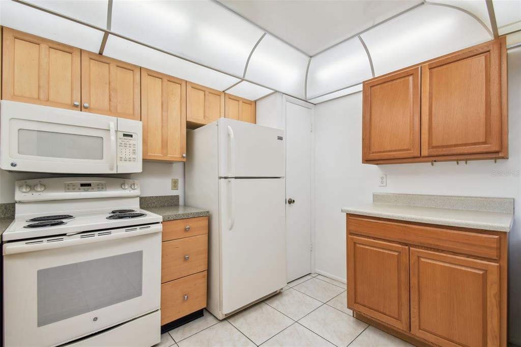 12300 Vonn Road, Unit 3102 Largo, FL 33774 - Photo 11 of 22 a kitchen with white cabinets and white appliances