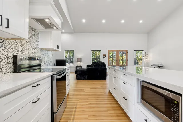 a kitchen with stainless steel appliances kitchen island granite countertop a stove a sink and a refrigerator