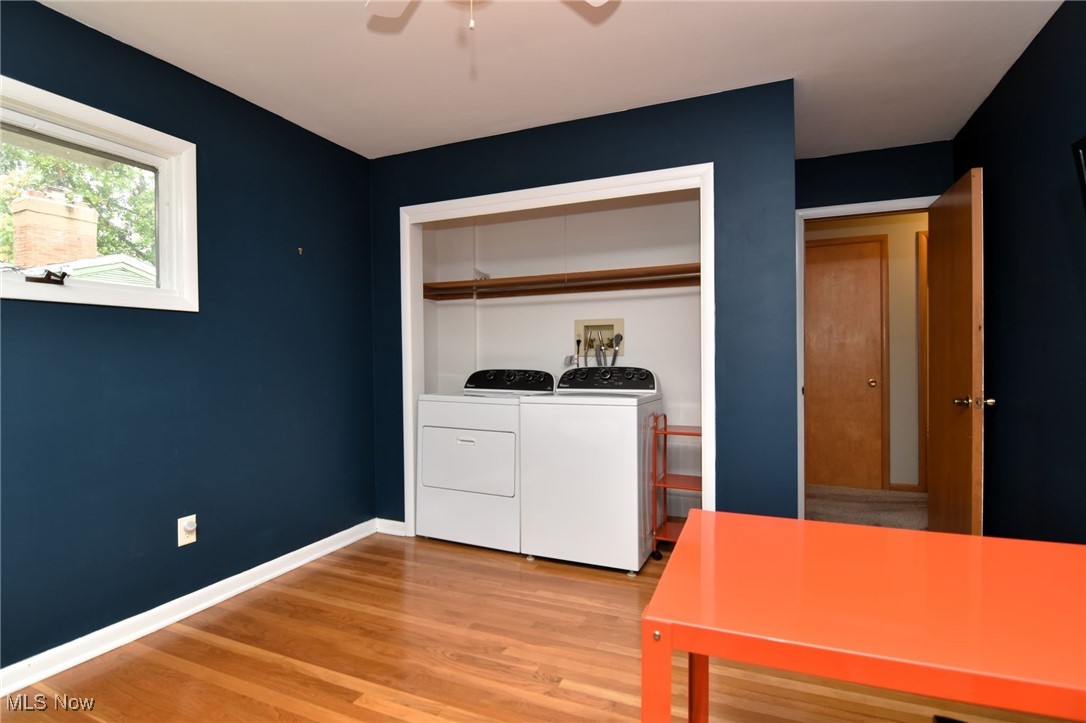 2071 Wyndham Road Akron, OH 44313 - Photo 21 of 42 Bedroom/office/Laundry room with ceiling fan, wood floor, and washing machine and dryer. First floor laundry could be moved back to basement.