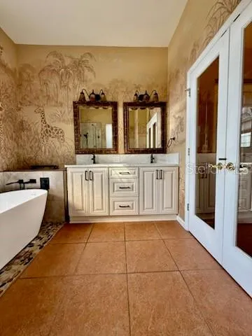 a spacious bathroom with a tub sink and mirror