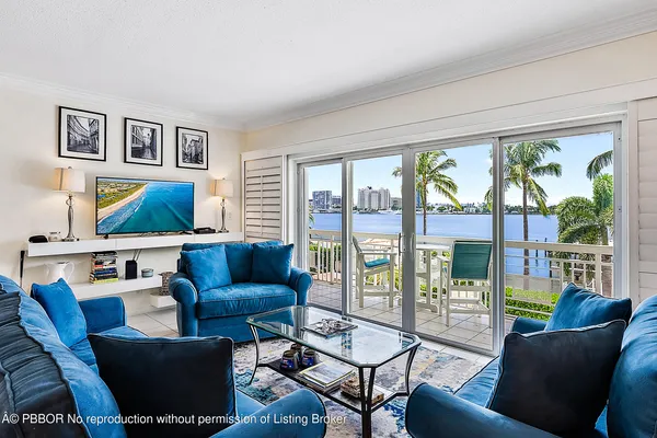 a kitchen with stainless steel appliances granite countertop a sink dishwasher a microwave oven a stove with white cabinets and chairs