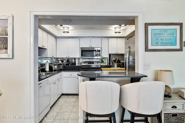 a kitchen with stainless steel appliances granite countertop a sink a stove and refrigerator