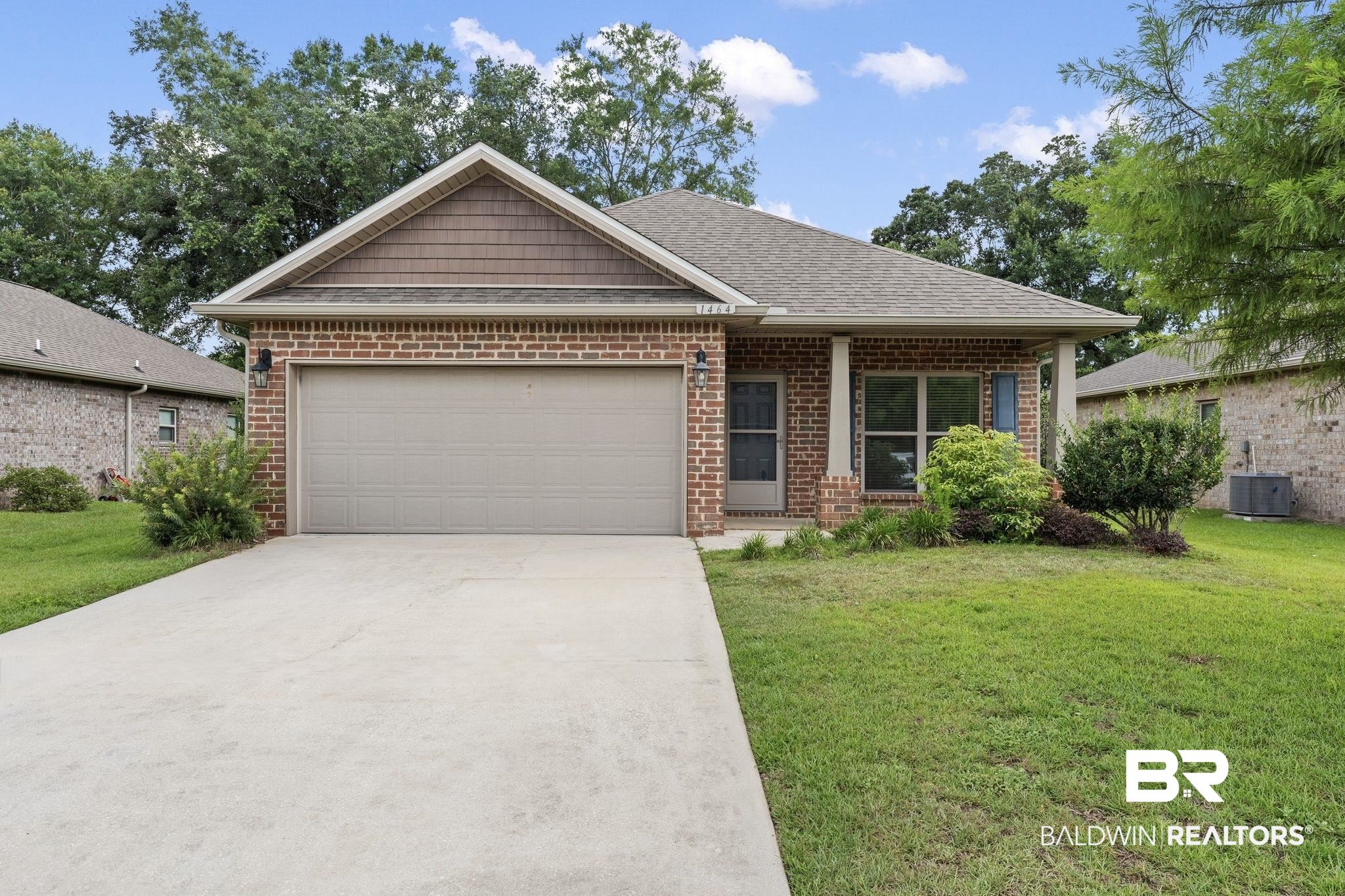1464 Surrey Loop Foley, AL 36535 - Photo 1 of 24 View of front of property featuring driveway, a garage, a front lawn, and brick siding