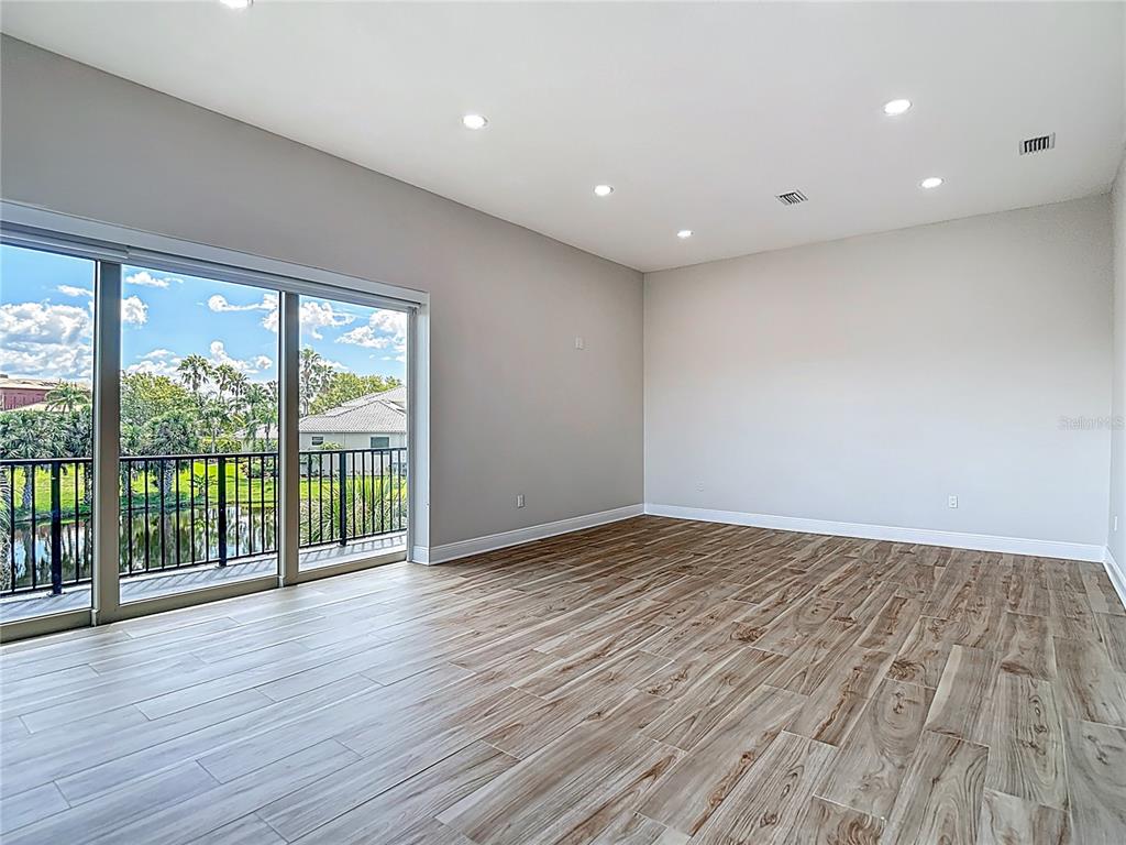 1329 Jumana Loop Apollo Beach, FL 33572 - Photo 19 of 40 a view of an empty room with wooden floor and a window