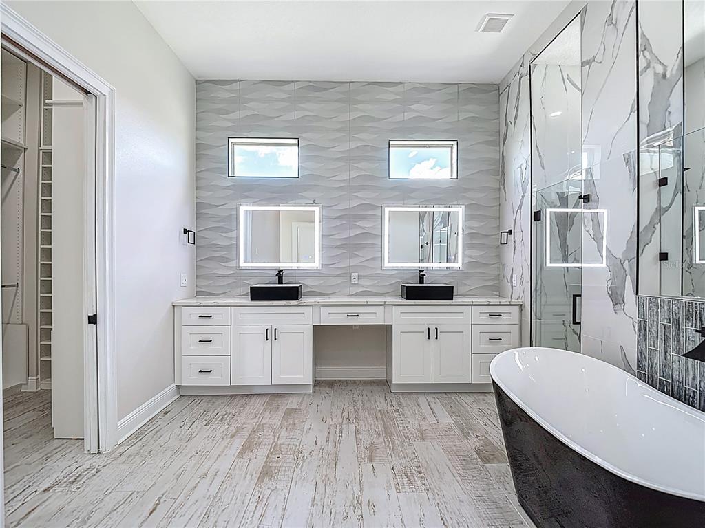 1329 Jumana Loop Apollo Beach, FL 33572 - Photo 25 of 40 a large bathroom with a granite countertop sink mirror and a bathtub