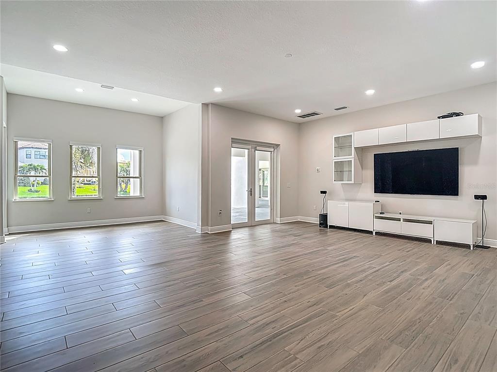 1329 Jumana Loop Apollo Beach, FL 33572 - Photo 36 of 40 a view of an empty room with wooden floor and windows