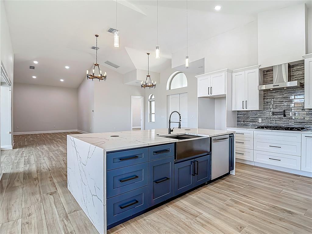 1329 Jumana Loop Apollo Beach, FL 33572 - Photo 7 of 40 a large kitchen with stainless steel appliances granite countertop a large stove a sink dishwasher and a refrigerator with wooden floor