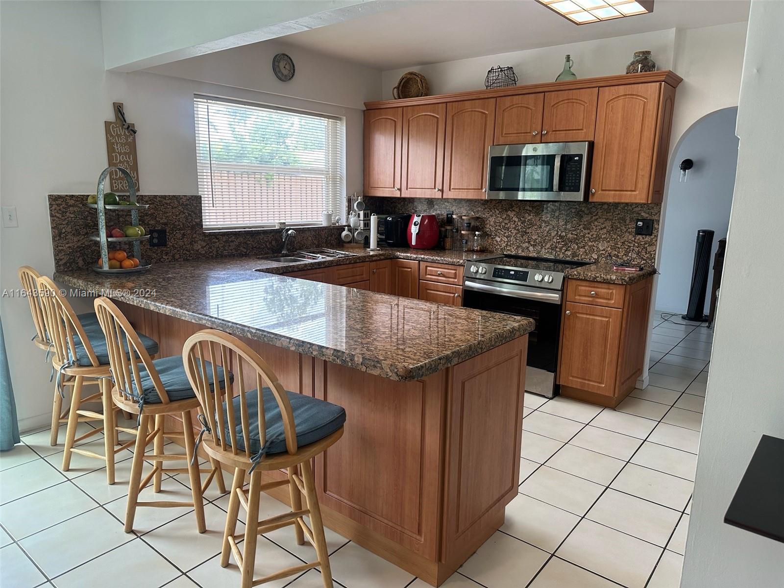 14200 Kendale Lakes Drive Miami, FL 33183 - Photo 3 of 21 a kitchen with stainless steel appliances granite countertop a stove a sink a microwave and a refrigerator