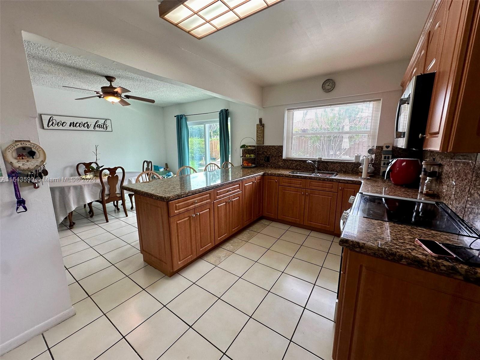14200 Kendale Lakes Drive Miami, FL 33183 - Photo 4 of 21 a kitchen with granite countertop a sink and a stove top oven