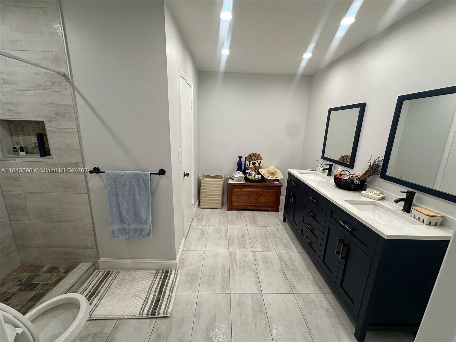 14200 Kendale Lakes Drive Miami, FL 33183 - Photo 9 of 21 a bathroom with a sink a toilet a mirror and shower