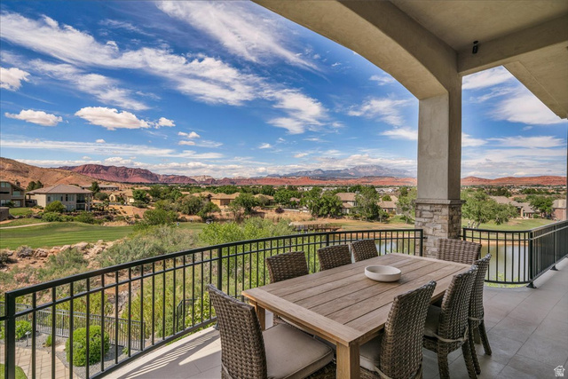 2608 Canyon Ridge Drive St. George, UT 84770 - Photo 45 of 86 Expansive covered deck featuring a stone-clad column, black wrought iron railing, and tiled flooring