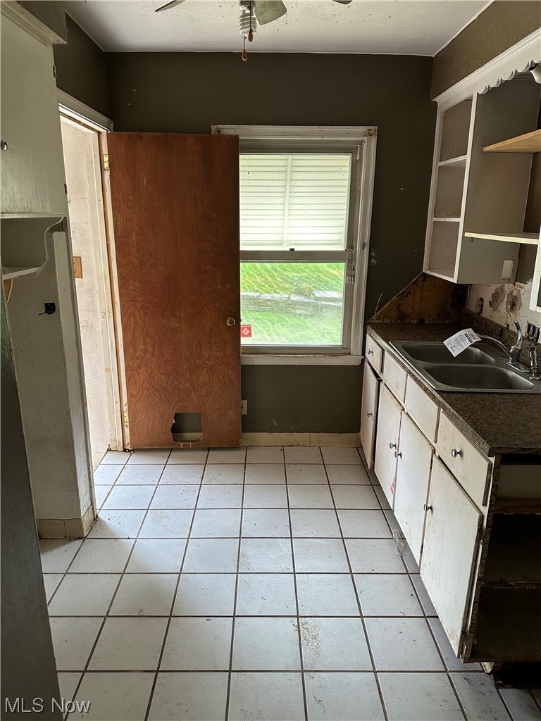 176 East Wilbeth Road Akron, OH 44301 - Photo 7 of 17 Kitchen with white cabinets, ceiling fan, sink, and light tile floors