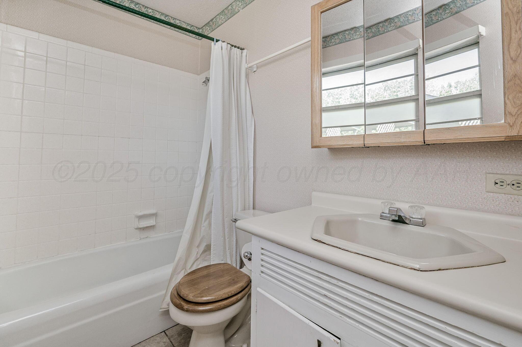 4701 Mesa Circle Amarillo, TX 79109 - Photo 15 of 20 a bathroom with a sink a toilet and a bathtub