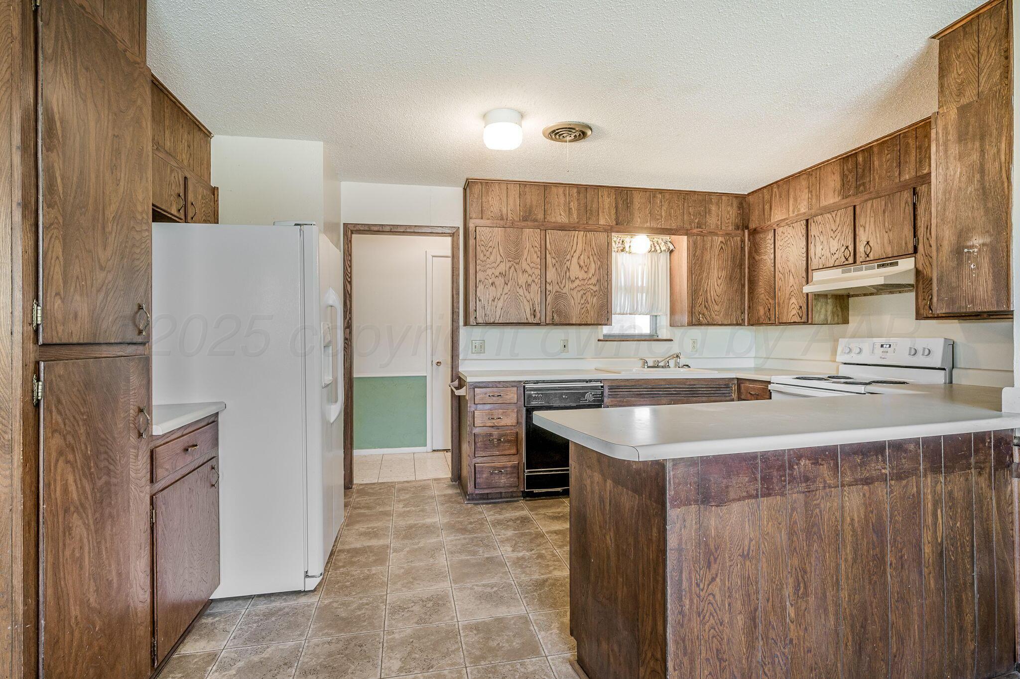 4701 Mesa Circle Amarillo, TX 79109 - Photo 4 of 20 a kitchen with a sink a stove a refrigerator and a window