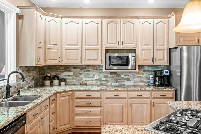 a dining room with wooden floor a chandelier a wooden table and chairs