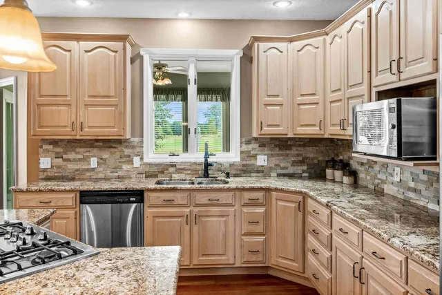 a dining room with wooden floor a chandelier a wooden table and chairs