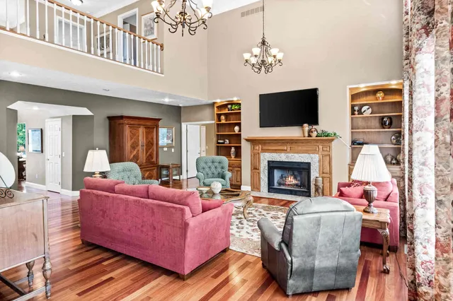 a kitchen with stainless steel appliances granite countertop a refrigerator a stove and white cabinets with wooden floors