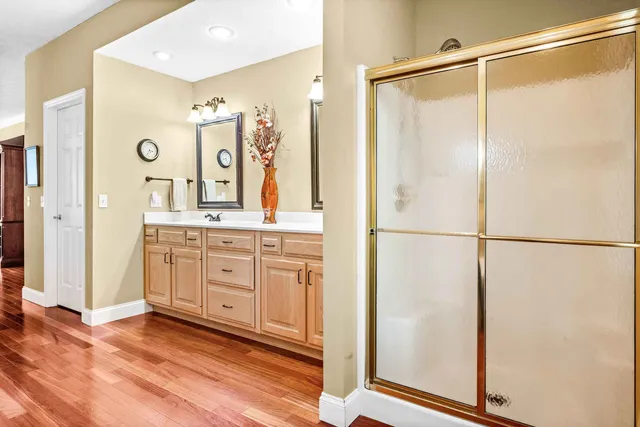 a en suite bathroom with a granite countertop sink and a mirror
