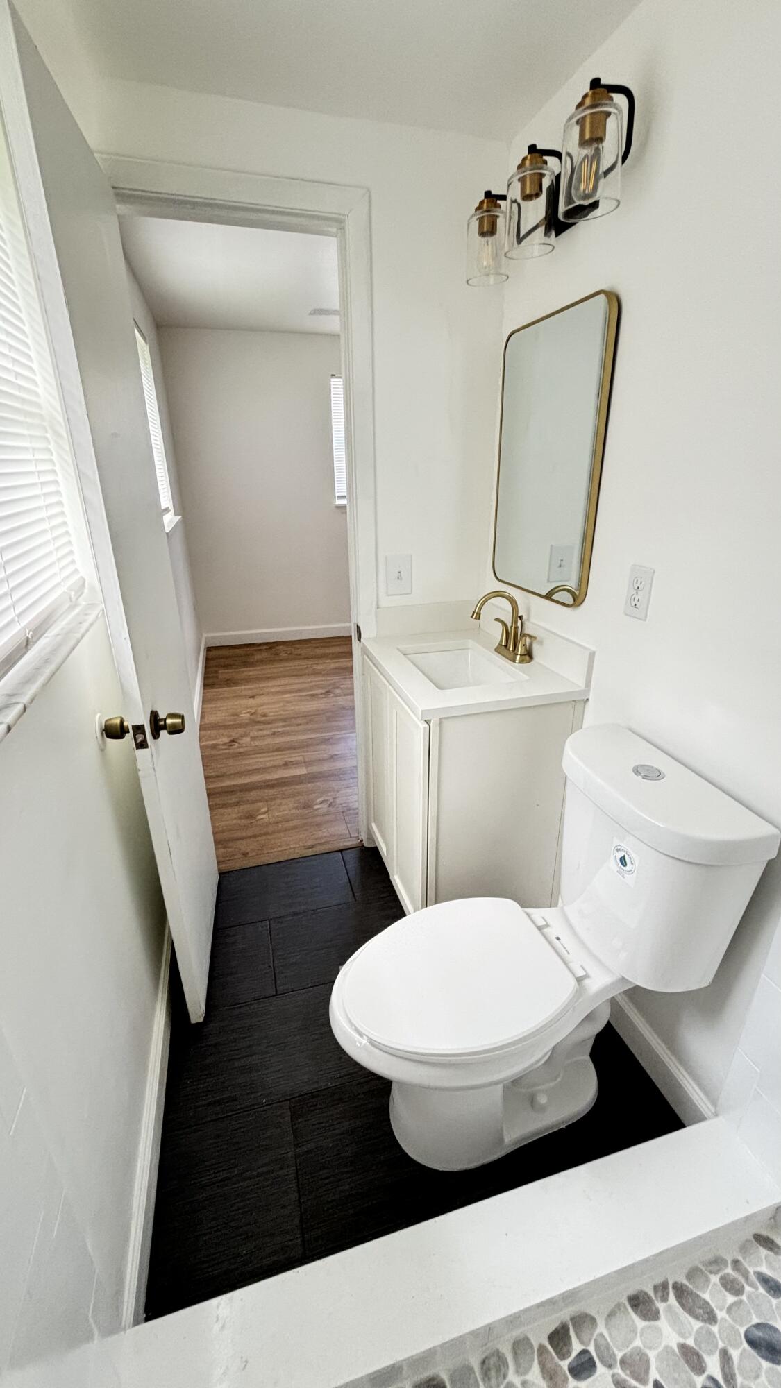 3945 Ocala Road Lake Worth, FL 33462 - Photo 15 of 18 a bathroom with a toilet sink and mirror