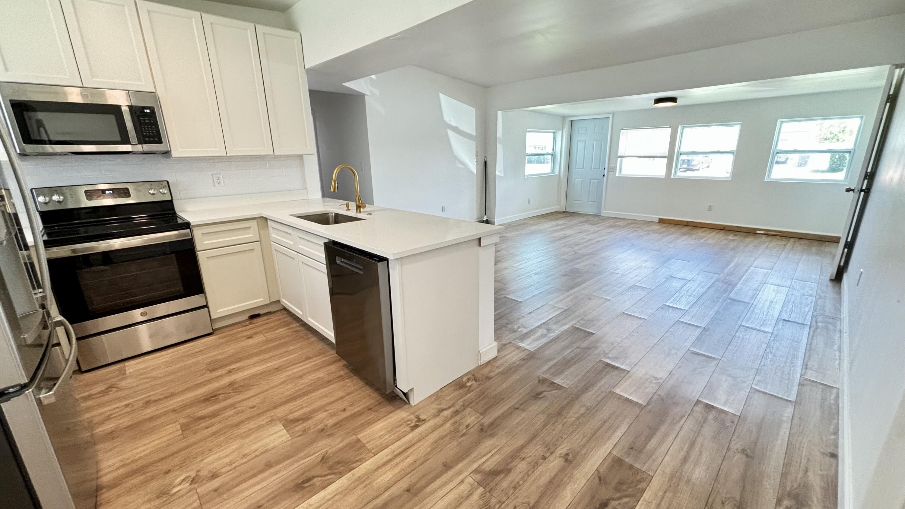 3945 Ocala Road Lake Worth, FL 33462 - Photo 4 of 18 a kitchen with granite countertop a stove and a sink