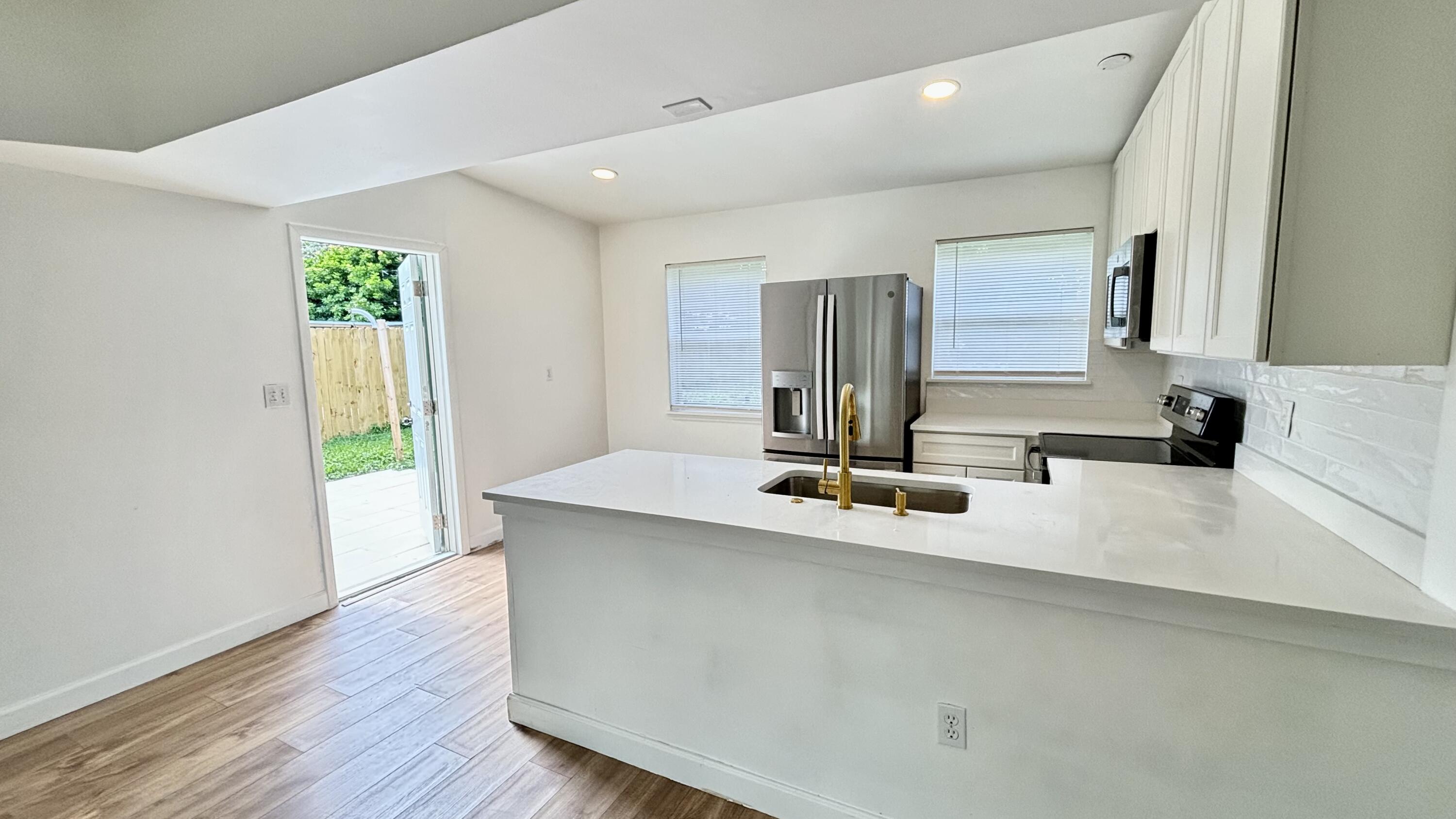 3945 Ocala Road Lake Worth, FL 33462 - Photo 5 of 18 a kitchen with kitchen island granite countertop a sink and a stove top oven