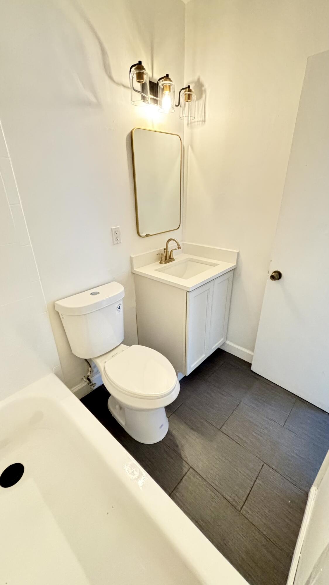 3945 Ocala Road Lake Worth, FL 33462 - Photo 8 of 18 a bathroom with a toilet sink and mirror