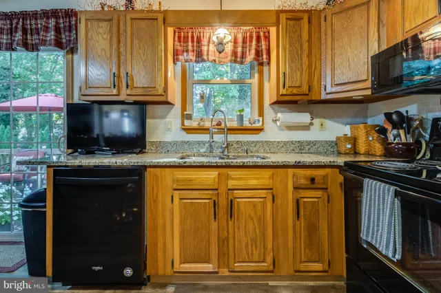 a kitchen with granite countertop a stove a sink and a microwave