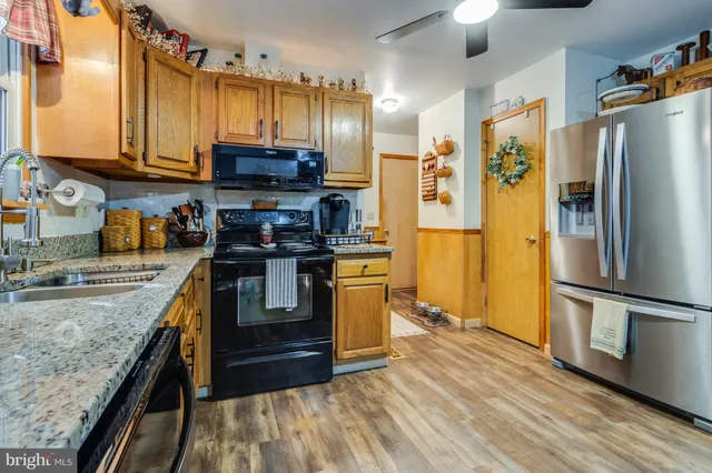 a kitchen with stainless steel appliances granite countertop a stove a refrigerator and a sink