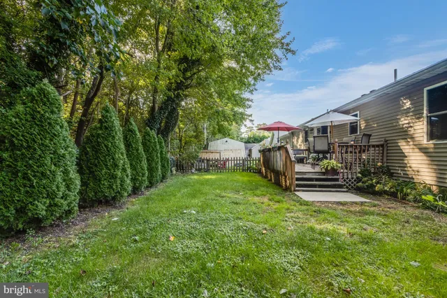 a view of a chair and table in backyard of the house