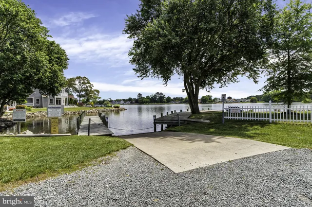 a view of a lake with a bench next to a yard